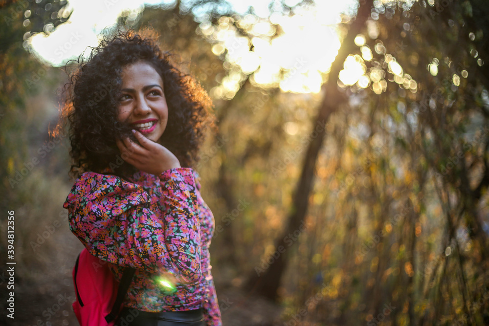 cheerful mexican young woman on the field at sunset, Beautiful woman with gorgeous curly hair in the sunlight cheerful mexican young woman on the field at sunset, Beautiful woman with gorgeous curly hair in the sunlight