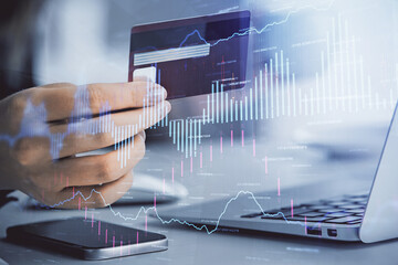 Multi exposure of woman on-line shopping holding a credit card and financial graph drawing. Stock market E-commerce concept.