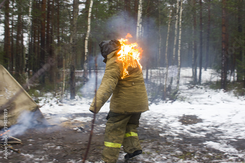 Ambulance drills in the winter forest. The woman stuntman caught fire from the fire and flees. Rescuers will have to demonstrate how to properly extinguish the fire and help if necessary.