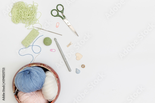 wool yarn for knitting and needlework, knitting hooks and accessories on a light background, with space