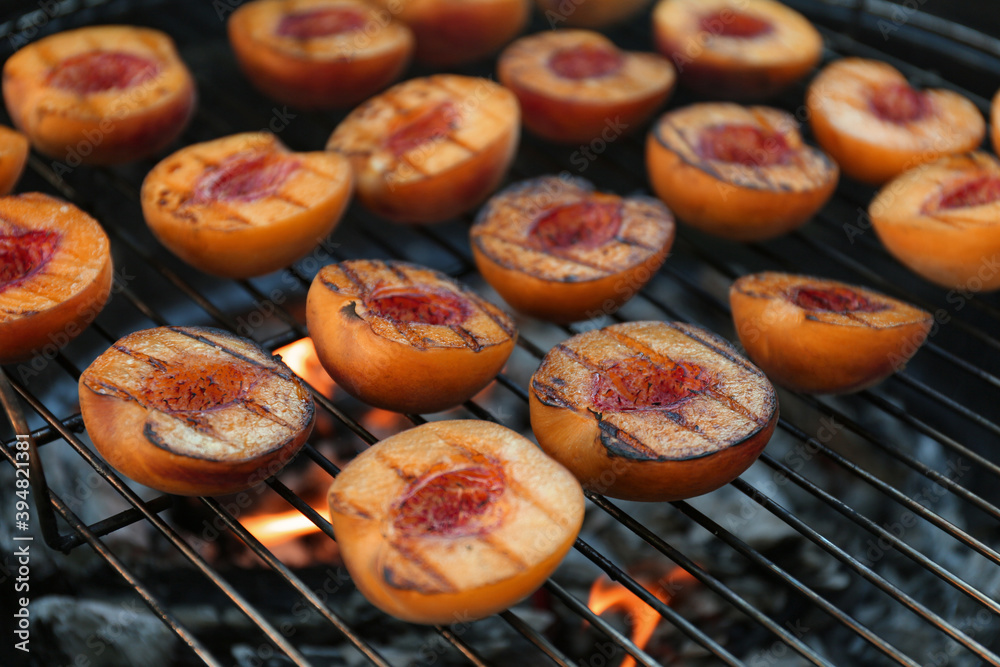 Modern grill with tasty cut peaches, closeup