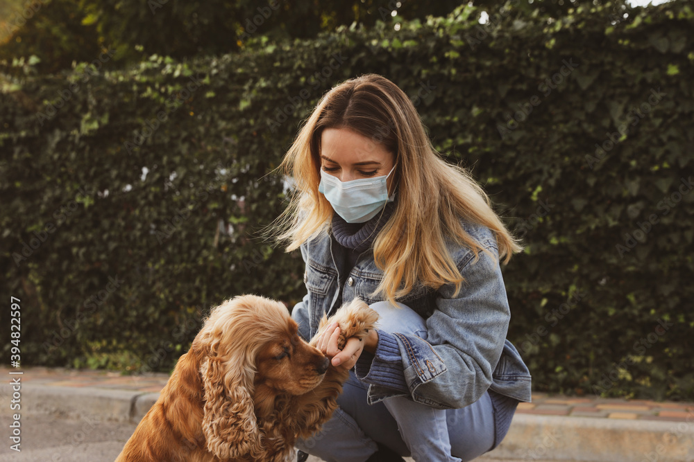 Woman in protective mask with English Cocker Spaniel outdoors. Walking dog during COVID-19 pandemic Woman in protective mask with English Cocker Spaniel outdoors. Walking dog during COVID-19 pandemic