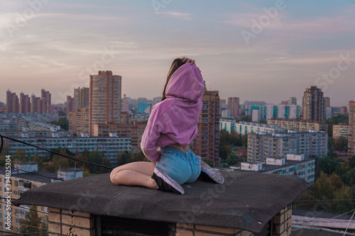 
girl in pink hoodie sitting on the roof