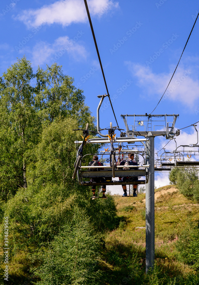 Extreem outdoor sport challenge in French Alps mountains in summer, using lift for riding downhill on sport bike on special bicycle path