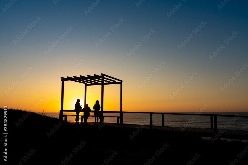 a group of young people in a viewpoint watching the sunset on the Portuguese beach of Sao Pedro de Moel - Portugal.