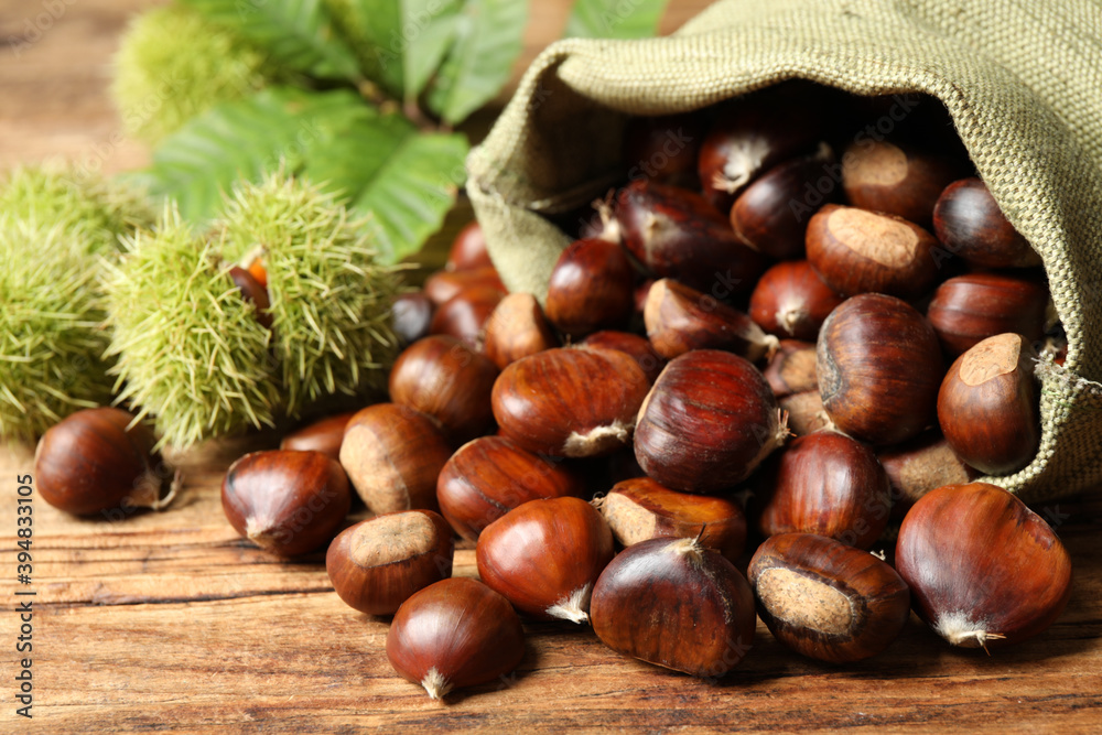 Fresh sweet edible chestnuts on wooden table, closeup Fresh sweet edible chestnuts on wooden table, closeup