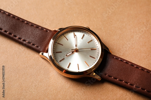 Luxury wrist watch on beige background, closeup
