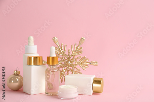Beautiful composition with cosmetic products on pink background  space for text. Winter care