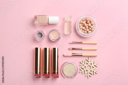 Flat lay composition with decorative cosmetic products on pink background. Winter care