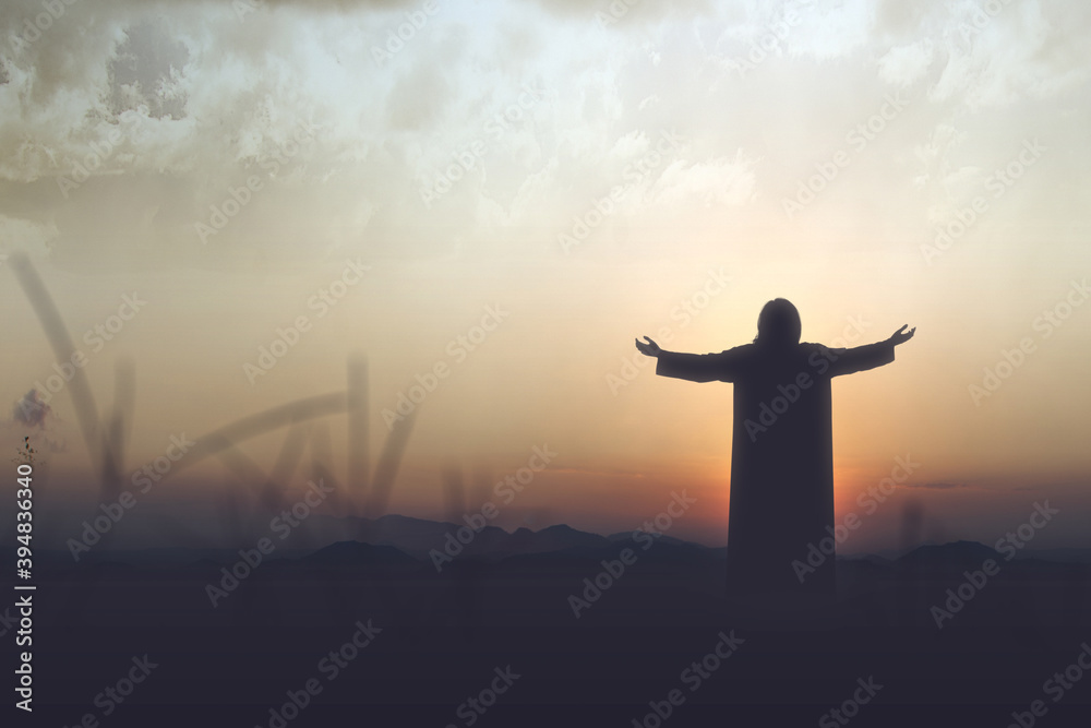 Rear view silhouette of Jesus Christ raised hands and praying to god