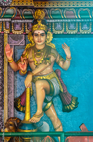 Kadirampura, Karnataka, India - November 4, 2013: Sri Murugan Temple. Colorful statue of young male Dwarapalaka guard with club at entrance. 