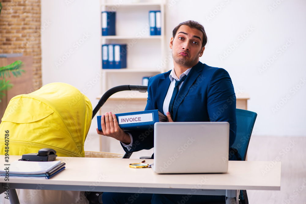 Young male employee looking after kid at workplace Young male employee looking after kid at workplace