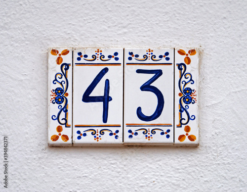 Street sign number 43 on a white wall 