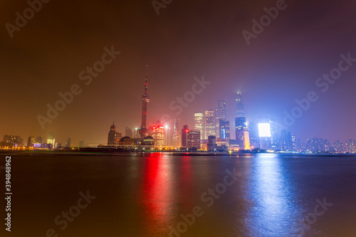 Shanghai skyline at night with river and lights