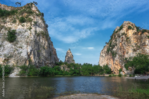 Khao Ngu Stone Stone mountain with blue sky and lake in front.