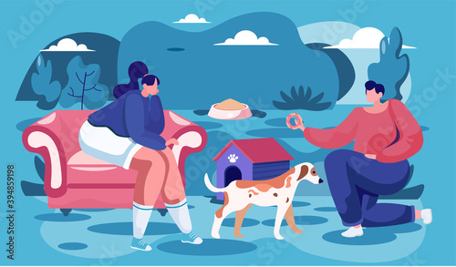 Man and woman pet owners sitting with a dog, teach him commands in the evening for a walk. Funny girl training her domestic animal outdoor. Owner with her tender doggy, people feed a sad stray dog