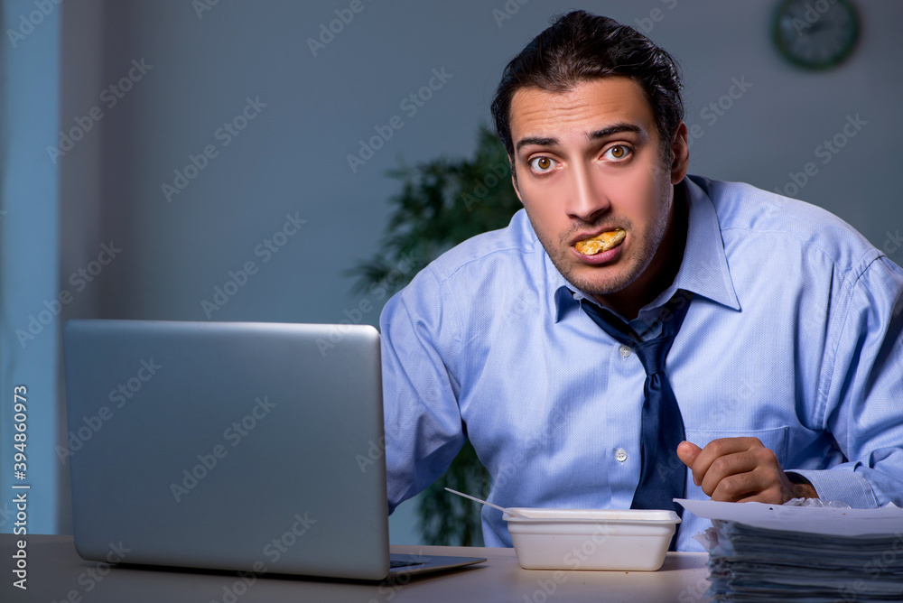 Hungry employee working late in the office Hungry employee working late in the office