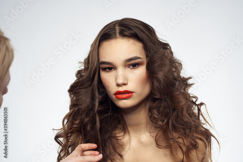 woman with bare shoulders wavy hairstyle glamor makeup light background