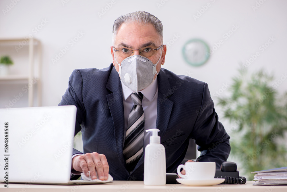 Old male boss employee working during pandemic