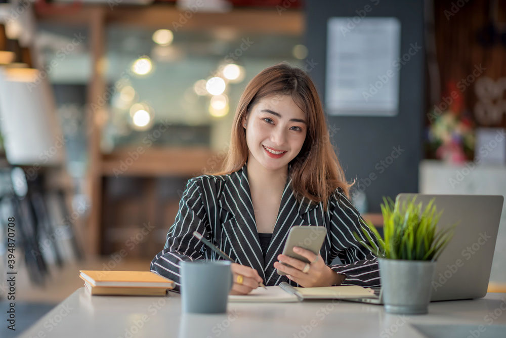 Young asian happy cheerful businesswoman using smartphone in office. Young asian happy cheerful businesswoman using smartphone in office.