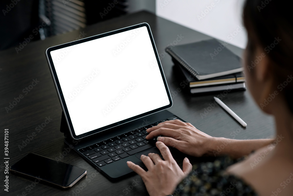 Close up. Woman hand typing on digital tablet keyboard with blank screen on desk at office. Close up. Woman hand typing on digital tablet keyboard with blank screen on desk at office.