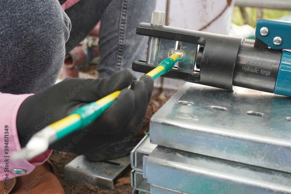 Hydraulic tongs crimping that is used by workers to crimp ground wires ...