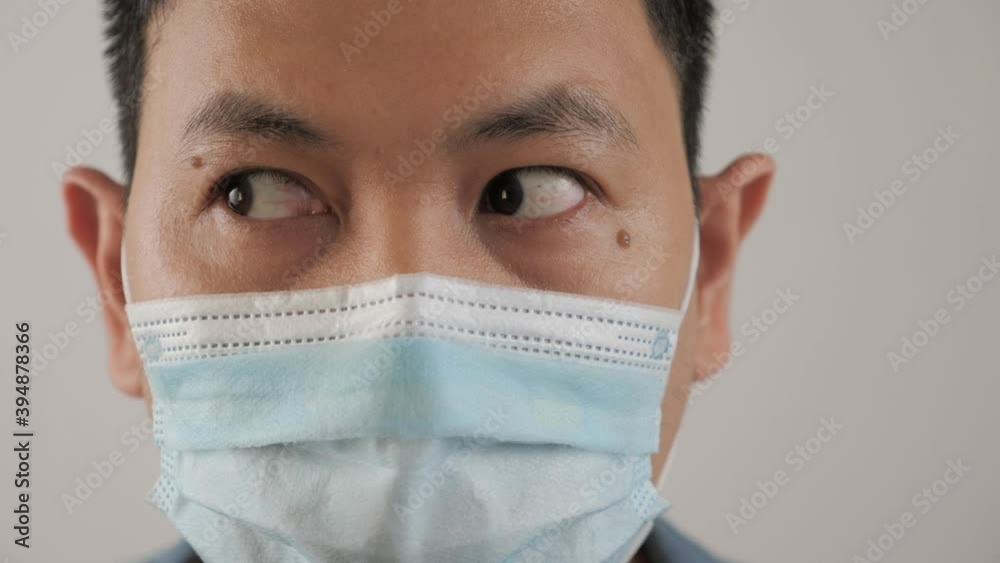 Man wearing protective facial mask. His eyes looking side to side, nervous worried expression Man wearing protective facial mask. His eyes looking side to side, nervous worried expression