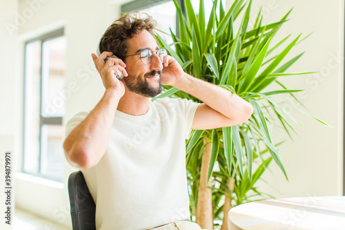 young bearded man listening music with his headphones photo