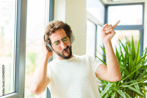 young bearded man listening music with his headphones photo