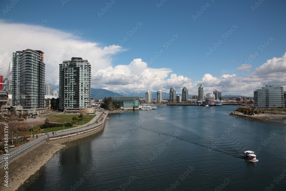 View of Vancouver False Creek waterfront skyline with snow mountain during springtime Seen from Cambie Bridge in the downtown of Vancouver, British Columbia, Canada. View of Vancouver False Creek waterfront skyline with snow mountain during springtime Seen from Cambie Bridge in the downtown of Vancouver, British Columbia, Canada.