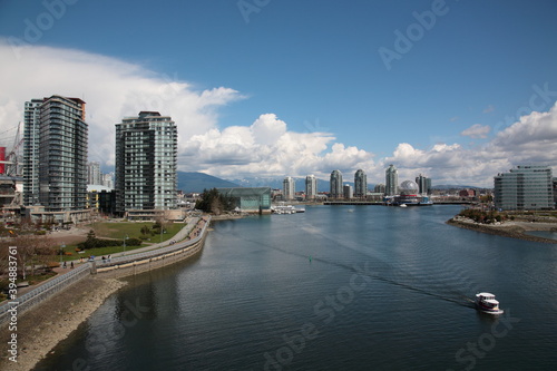 View of Vancouver False Creek waterfront skyline with snow mountain during springtime Seen from Cambie Bridge in the downtown of Vancouver, British Columbia, Canada.