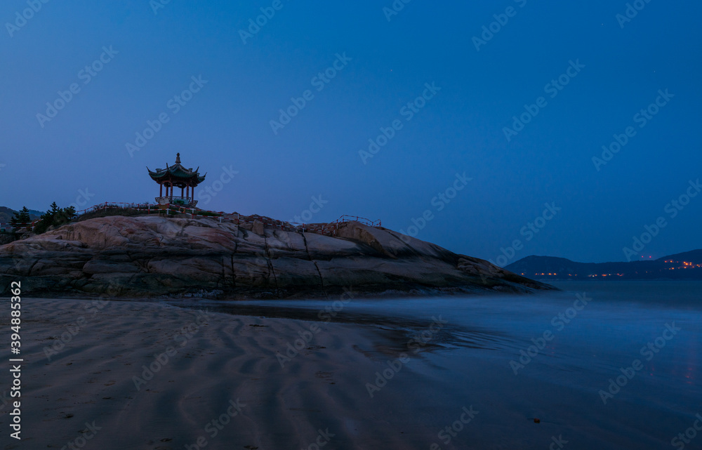 A Chinese traditional pavilion and rocks in the Putuoshan, Zhoushan Islands,  a renowned site in Chinese bodhimanda of the bodhisattva Avalokitesvara (Guanyin)