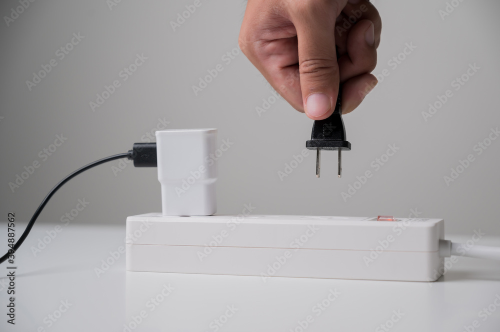 Hand holding Electric plug put on multiple socket. Electrical equipment ...