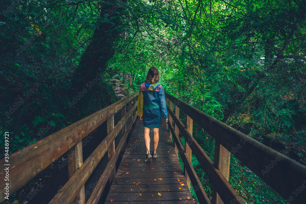 Young woman standing on a bridge in the forest