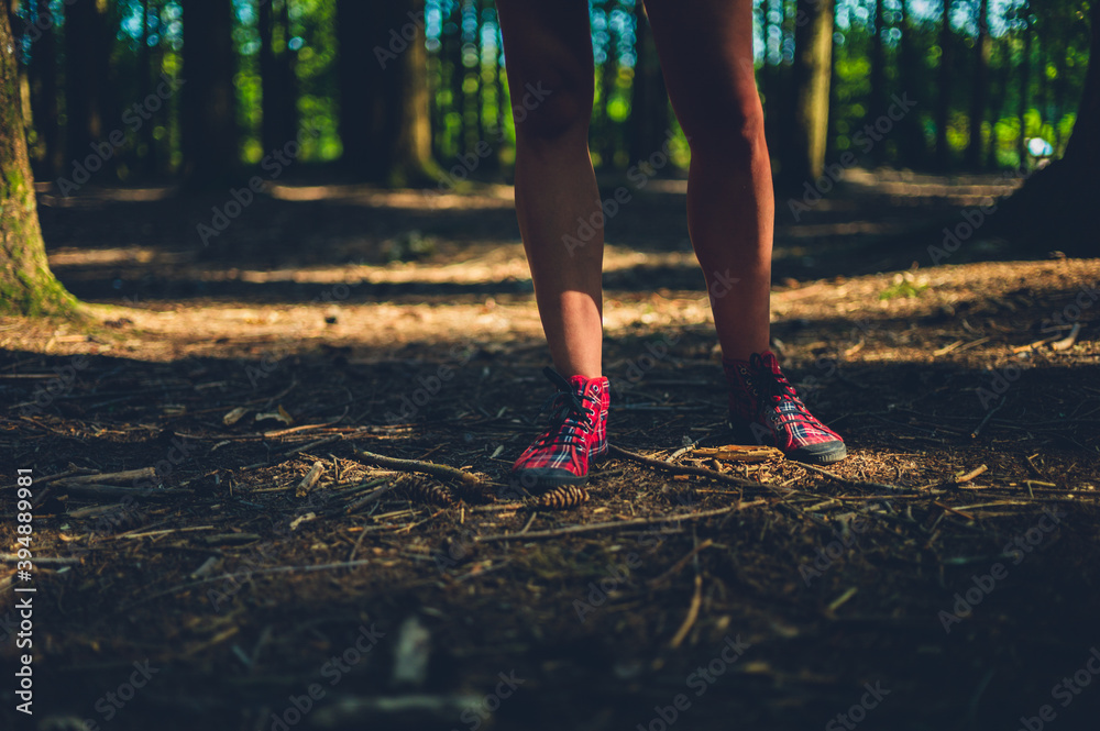 Feet and legs of a young woman standing in the forest Feet and legs of a young woman standing in the forest