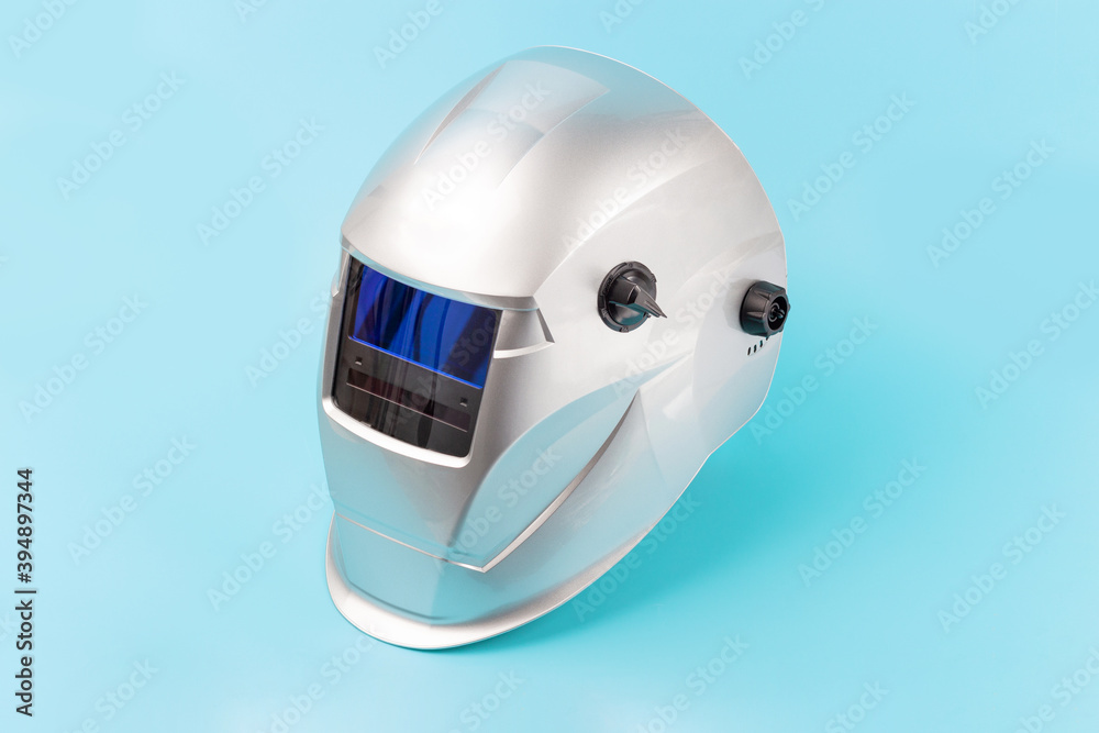 Fototapeta premium Welding mask isolated on blue background close-up.