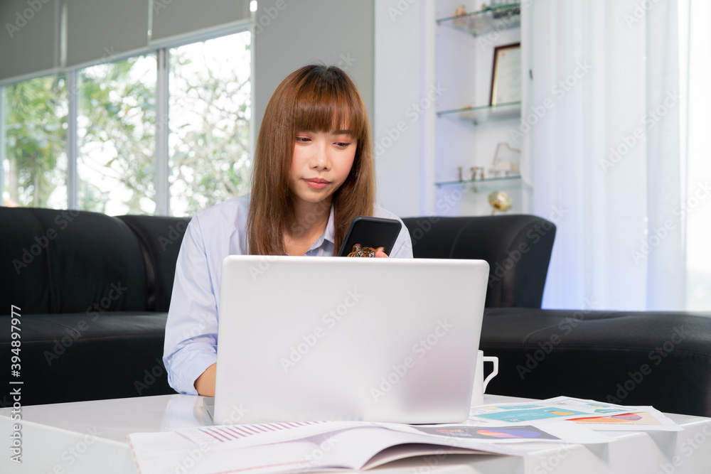 Work from Home, Beautiful young woman working on laptop computer while sitting at the living room, Online meeting from home and Phone calls with customers. Work from Home, Beautiful young woman working on laptop computer while sitting at the living room, Online meeting from home and Phone calls with customers.