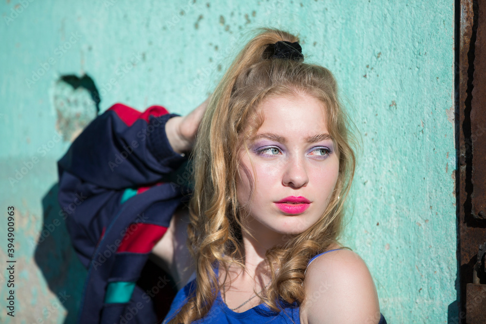 Portrait of a funny brunette girl with bright makeup in a sports trowel. Girl in the style of the eighties.