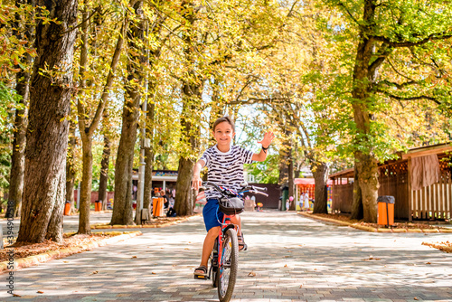 Wallpaper Mural A happy boy rides his bike through a summer park. Joyful child cycling on vacation Torontodigital.ca