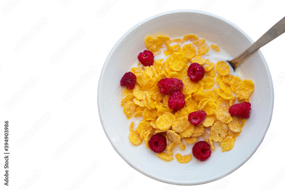 Cornflakes with raspberries on a white plate on a white background. Cornflakes with raspberries on a white plate on a white background.
