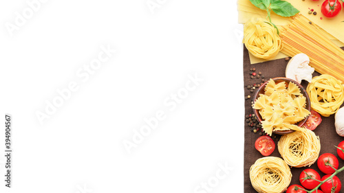 Assortment of uncooked pasta and vegetables on white background