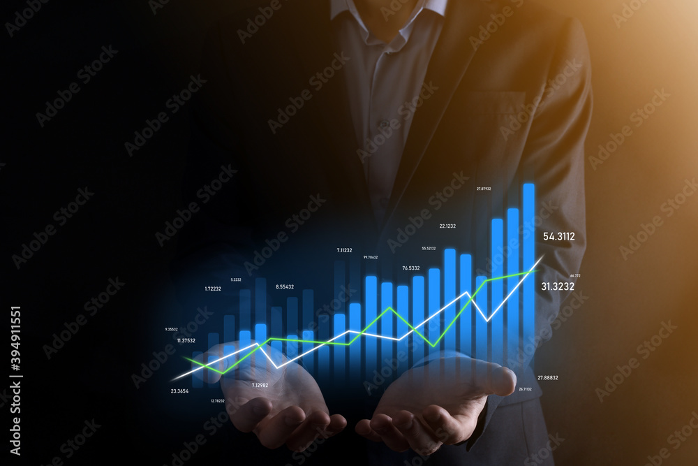Business man holding holographic graphs and stock market statistics gain profits. Concept of growth planning and business strategy. Display of good economy form digital screen. Business man holding holographic graphs and stock market statistics gain profits. Concept of growth planning and business strategy. Display of good economy form digital screen.