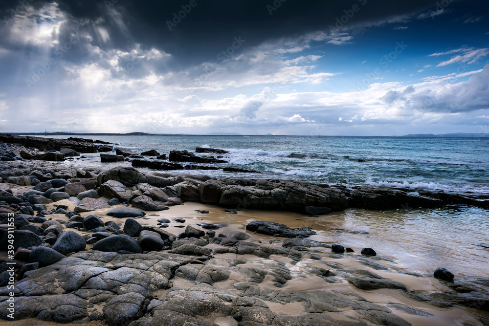 Stormy sky over rocky shoreline at low tide Stormy sky over rocky shoreline at low tide