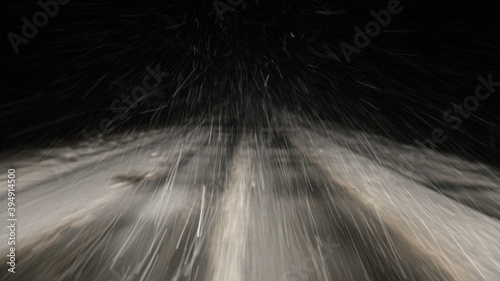 Obraz na płótnie Heavy snowfall, snowstorm on a winter road at night, a car driving on a white highway track with insufficient visibility, a view of the motorway from driver's windglass from inside a moving vehicle w salonie