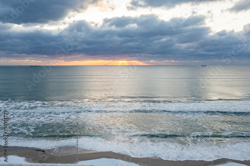 Fototapeta Naklejka Na Ścianę i Meble -  The cloudy and snowy day with sunset in beach.