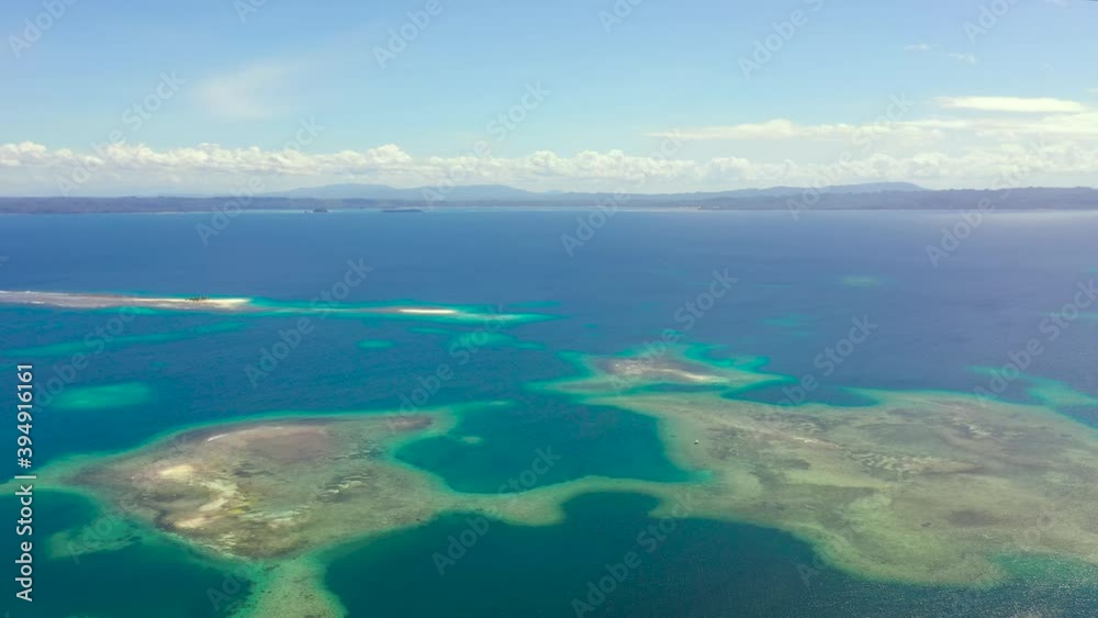 Aerial view of Tropical island with sand beach, palm trees by atoll with coral reef. Britania Islands, Surigao del Sur, Philippines. Aerial view of Tropical island with sand beach, palm trees by atoll with coral reef. Britania Islands, Surigao del Sur, Philippines.