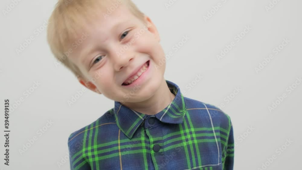 The boy in the studio on a white background smiles and rejoices into the camera. The boy in the studio on a white background smiles and rejoices into the camera.