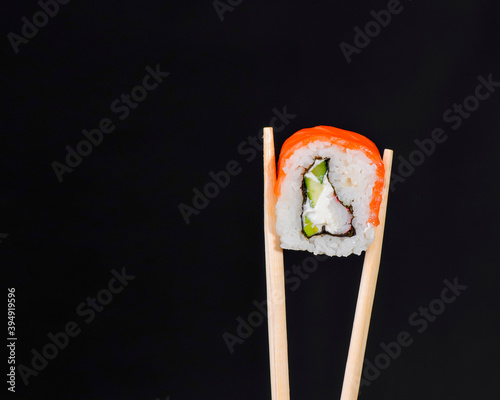 Vibrant sushi set, creative idea concept. Sushi in chopsticks, California or Philadelphia sushi rolls.