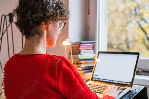Cuadro en lienzo Young Caucasian entrepreneur woman in red sweater working online from home on co