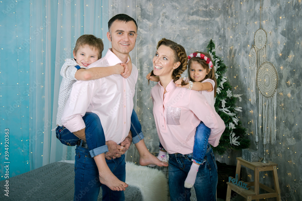 Family in home interior of Christmas and New Year. parents and children are happy together at christmas. 
Mom, dad, daughter, son 